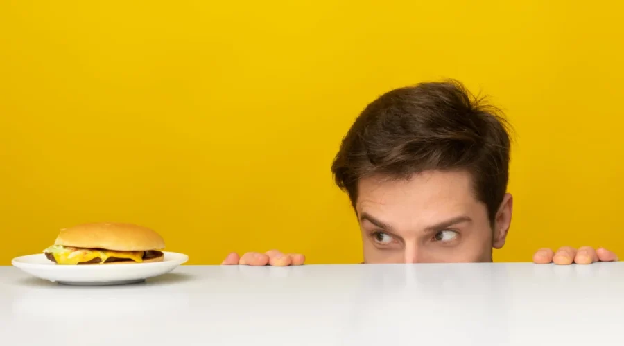 hombre mirando una hamburguesa